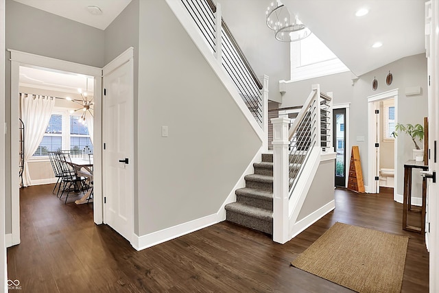 stairs with hardwood / wood-style floors and a notable chandelier