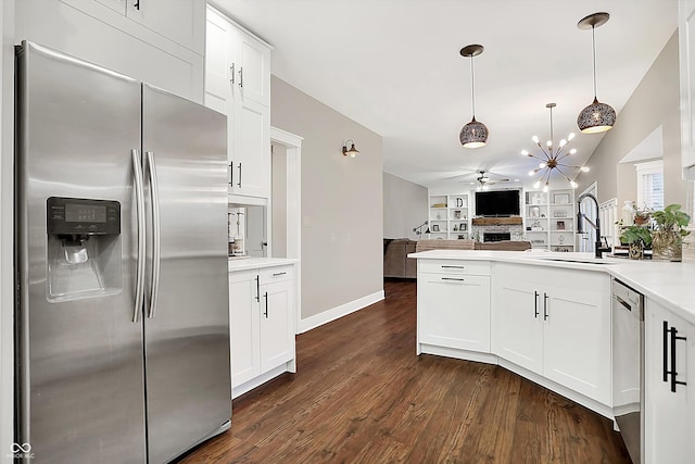 kitchen featuring sink, dark wood-type flooring, white cabinetry, hanging light fixtures, and stainless steel appliances