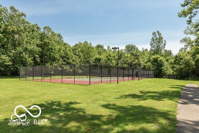 view of home's community with a yard and tennis court