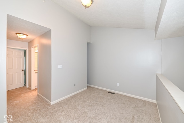 carpeted empty room with a textured ceiling