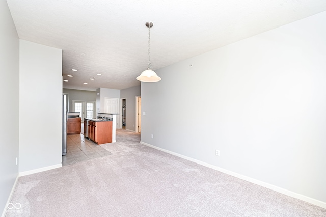 interior space featuring light colored carpet and a textured ceiling