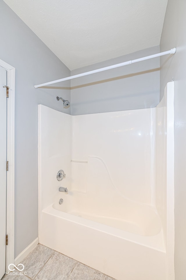 bathroom with tile patterned flooring and shower / washtub combination