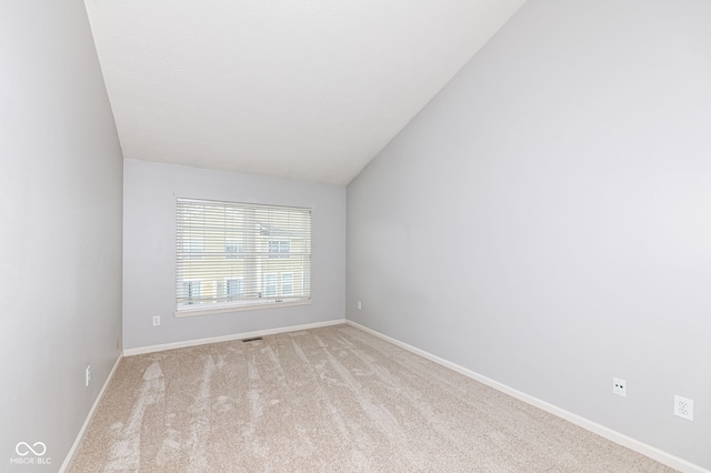 empty room with lofted ceiling and light carpet