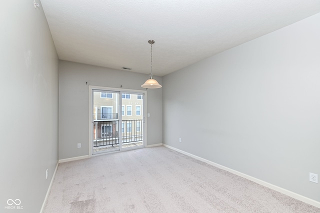 carpeted empty room with a textured ceiling