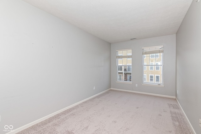 carpeted spare room featuring a textured ceiling