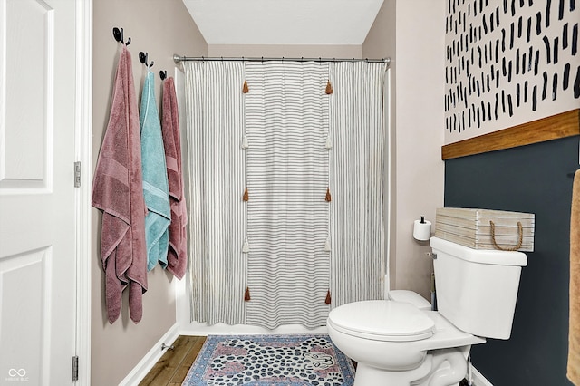 bathroom featuring hardwood / wood-style flooring, toilet, and a shower with shower curtain