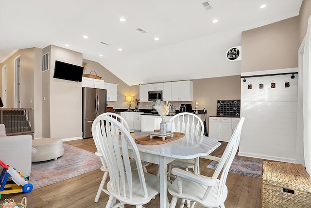 dining area featuring lofted ceiling and light hardwood / wood-style floors