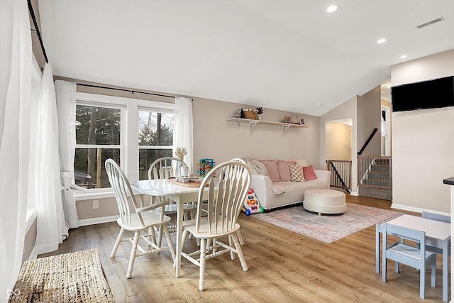 dining space with lofted ceiling and light wood-type flooring