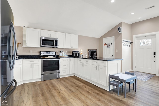 kitchen featuring white cabinetry, stainless steel appliances, kitchen peninsula, and light wood-type flooring