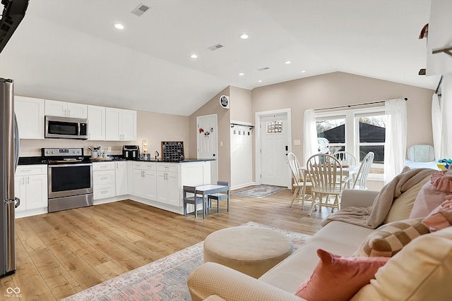 living room with vaulted ceiling and light hardwood / wood-style floors