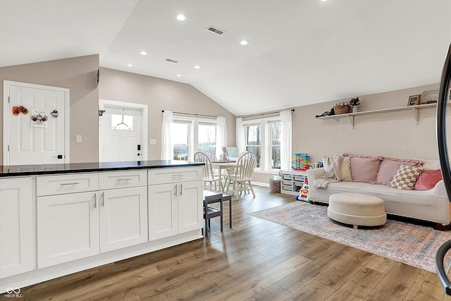 kitchen with white cabinetry, dark hardwood / wood-style floors, and vaulted ceiling