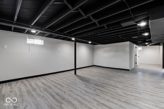 basement with light hardwood / wood-style flooring