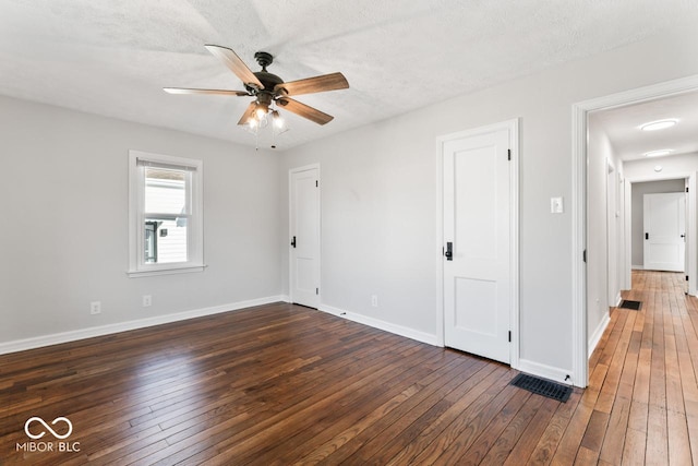 interior space with ceiling fan, dark wood-type flooring, and a textured ceiling