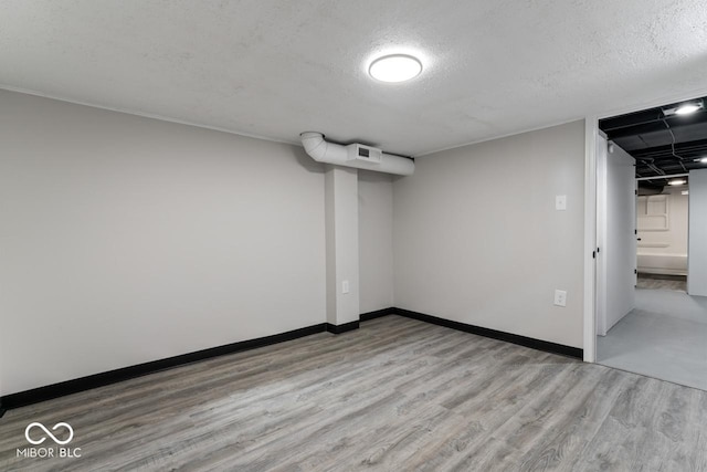 interior space with a textured ceiling and light hardwood / wood-style flooring