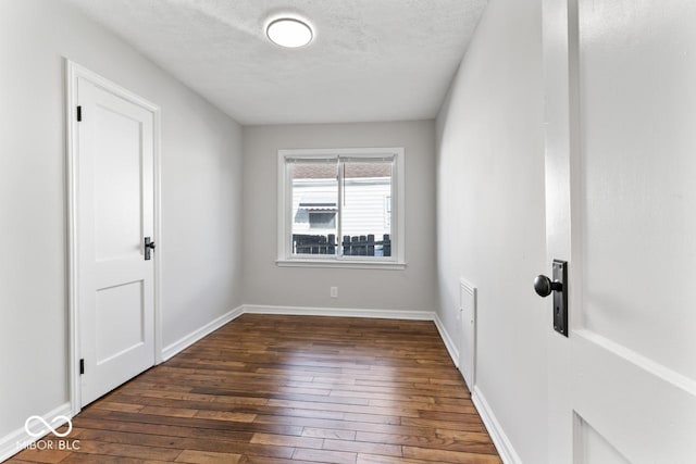 spare room with dark hardwood / wood-style floors and a textured ceiling