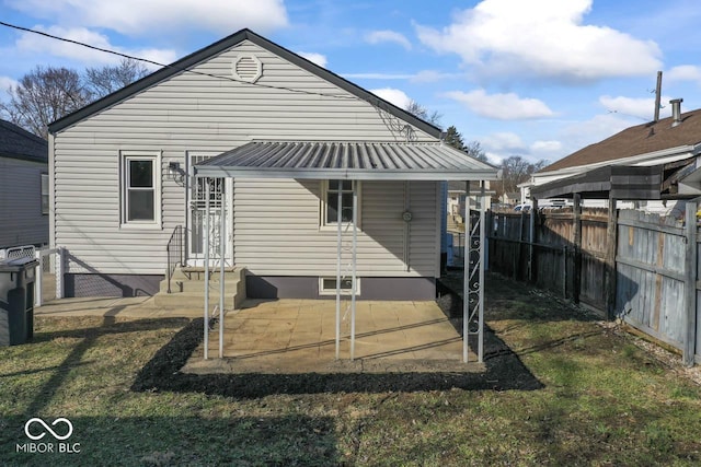 rear view of house with a patio and a lawn