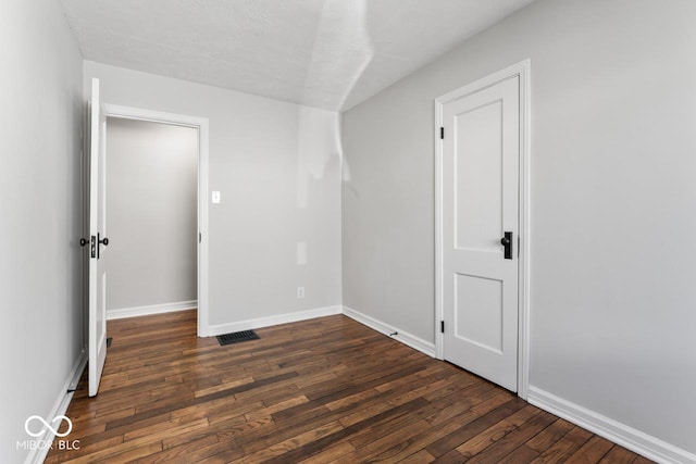 unfurnished room with dark wood-type flooring