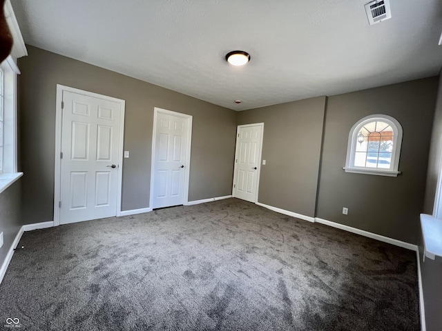 unfurnished bedroom featuring dark carpet