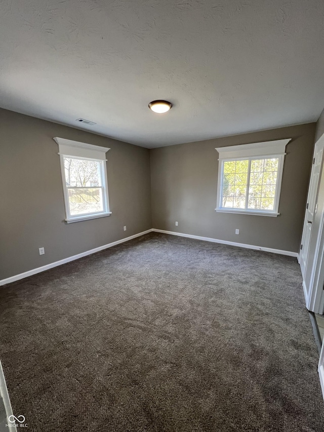 carpeted spare room featuring a textured ceiling