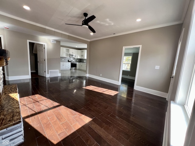 unfurnished living room with ceiling fan, ornamental molding, and dark hardwood / wood-style flooring