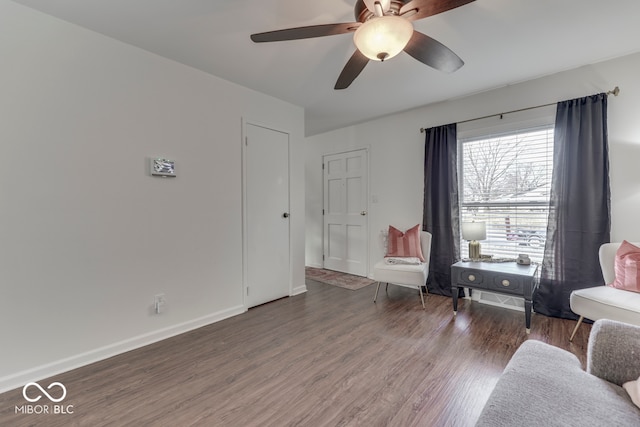 living area with dark wood-type flooring and ceiling fan