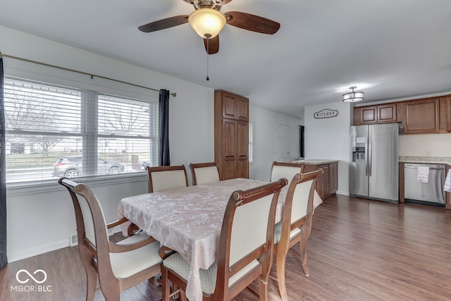 dining room with dark wood-type flooring and ceiling fan