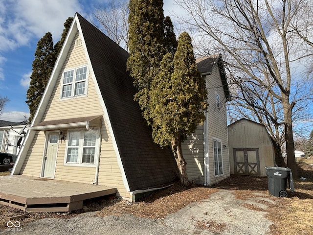 exterior space featuring a deck and a storage shed