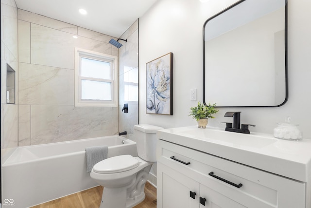 full bathroom featuring tiled shower / bath, vanity, toilet, and hardwood / wood-style floors