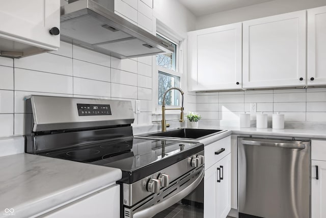 kitchen featuring white cabinetry, extractor fan, and appliances with stainless steel finishes