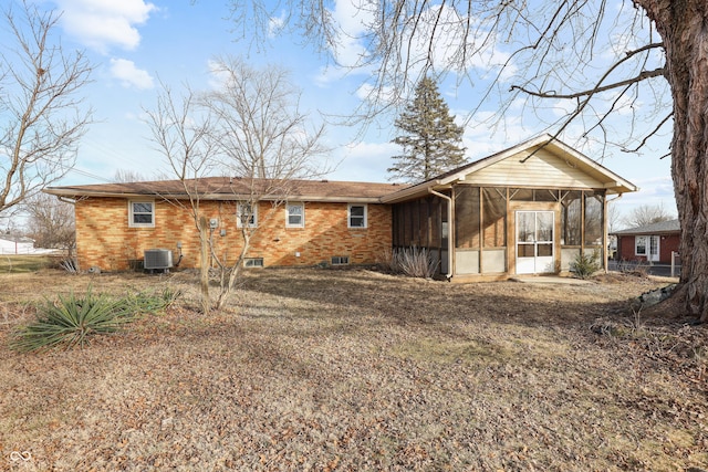 rear view of house featuring central AC unit and a sunroom