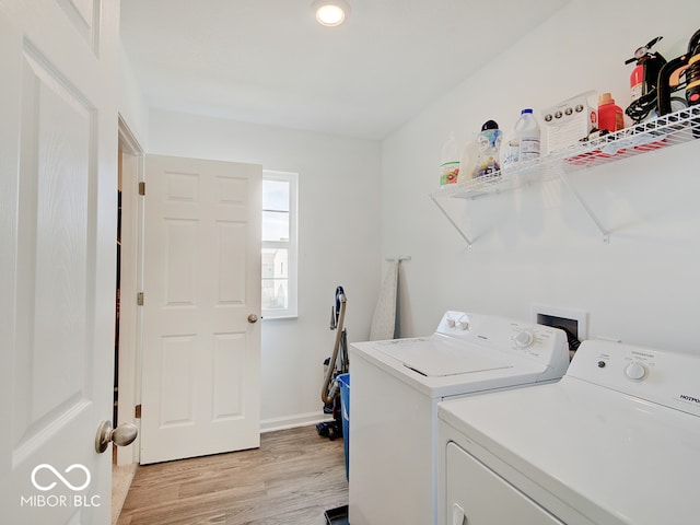 washroom with independent washer and dryer and light hardwood / wood-style flooring