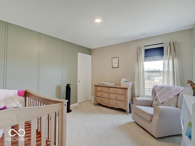 carpeted bedroom with a nursery area