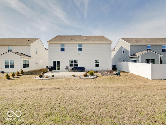 back of house featuring a lawn and a patio