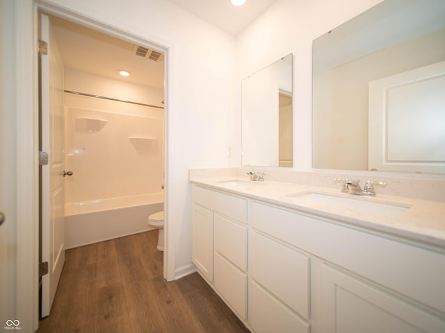 bathroom with visible vents, a sink, toilet, and wood finished floors