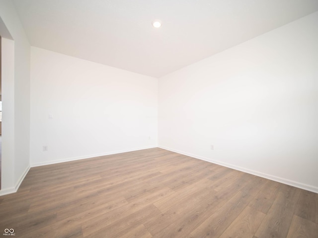 unfurnished room with baseboards, wood finished floors, and recessed lighting