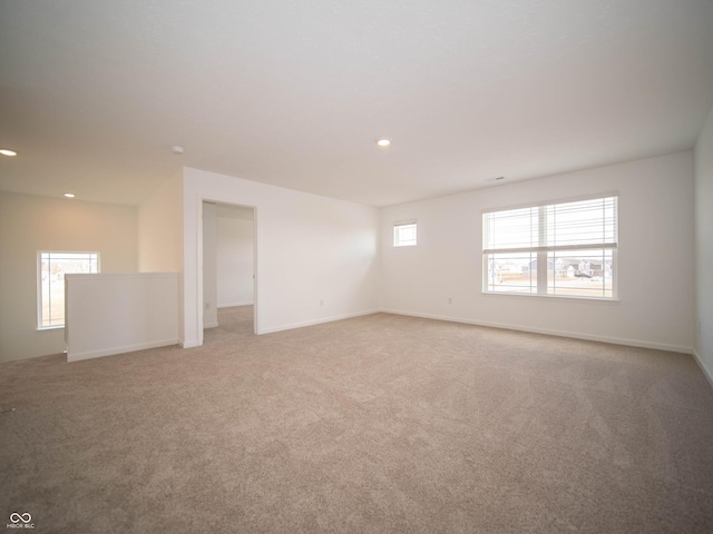 carpeted spare room featuring baseboards and recessed lighting