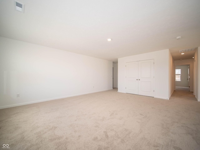 unfurnished bedroom with a closet, light carpet, visible vents, and baseboards