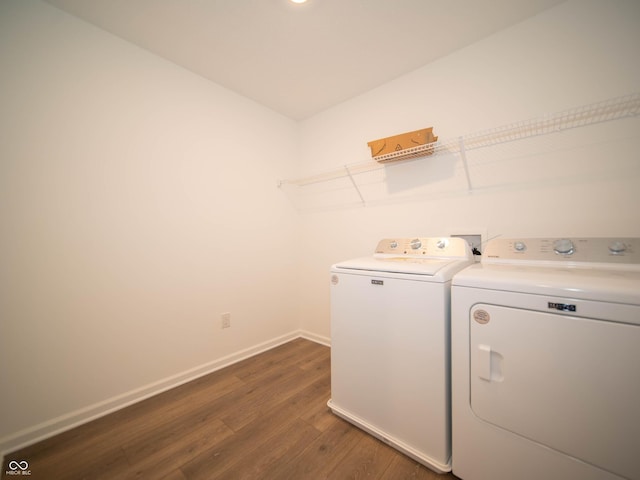 clothes washing area with laundry area, baseboards, dark wood finished floors, and independent washer and dryer