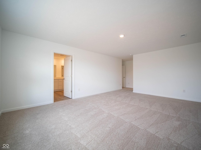 empty room with recessed lighting, light colored carpet, and baseboards