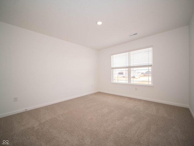 spare room featuring carpet, visible vents, baseboards, and recessed lighting