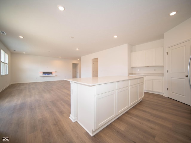 kitchen with recessed lighting, a center island, white cabinets, and wood finished floors