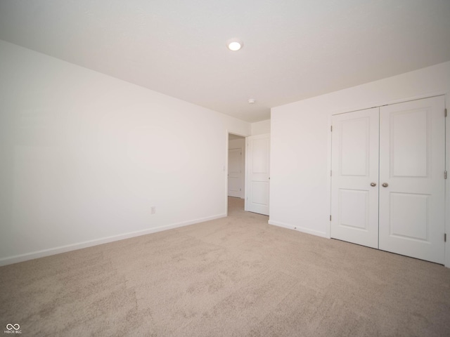 unfurnished bedroom with carpet floors, a closet, and baseboards