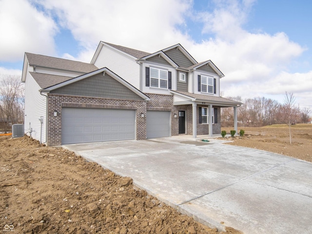 view of front facade with an attached garage, a porch, concrete driveway, and brick siding