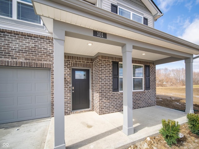 property entrance with covered porch and brick siding