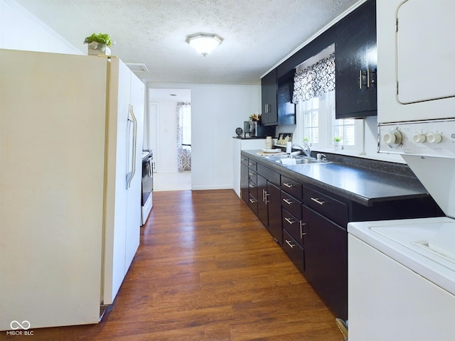 kitchen featuring white appliances, dark hardwood / wood-style flooring, sink, and a textured ceiling