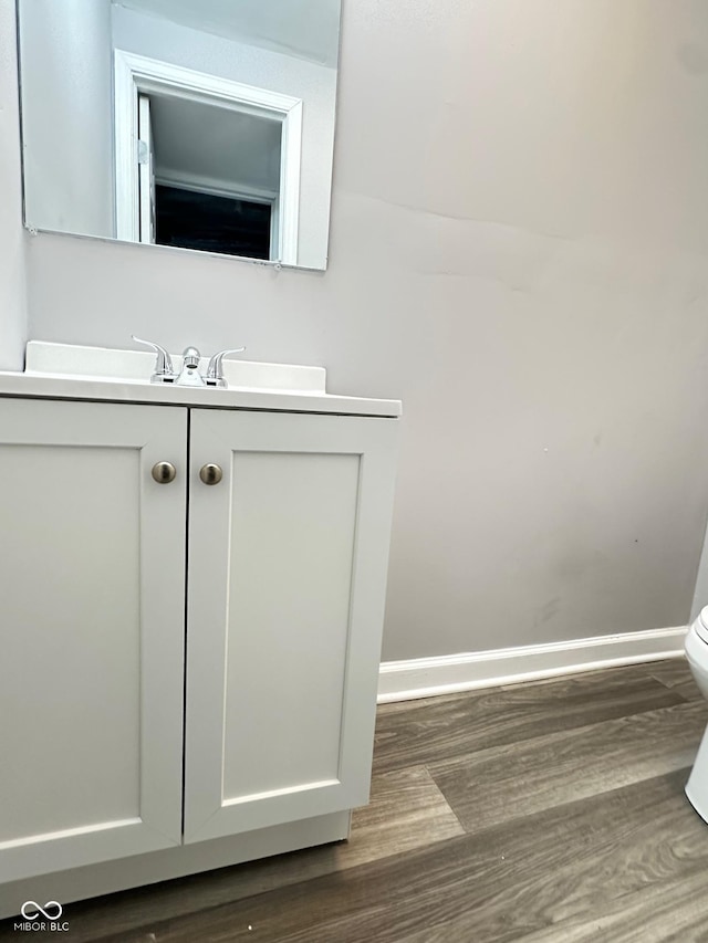 bathroom with vanity, wood-type flooring, and toilet