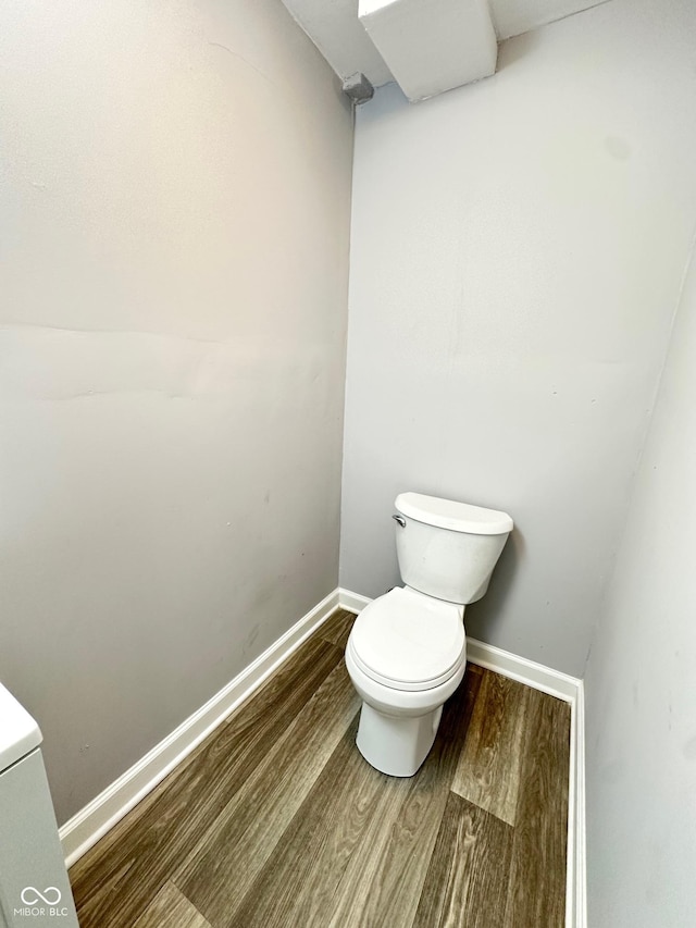 bathroom featuring wood-type flooring and toilet