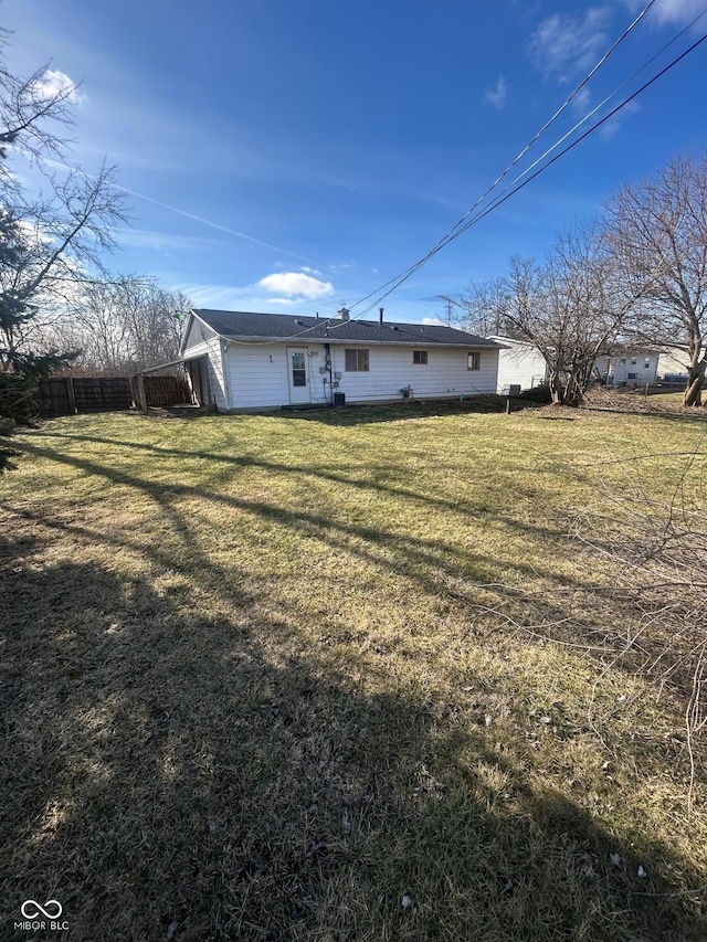 rear view of house featuring a lawn