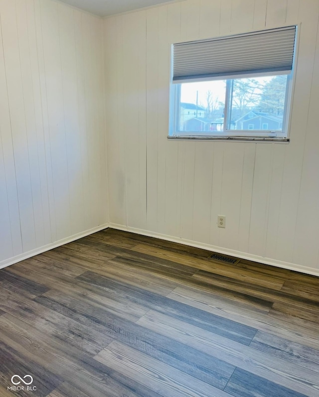 empty room with plenty of natural light and dark hardwood / wood-style floors