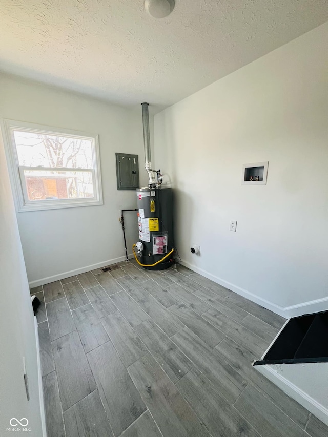 utility room featuring gas water heater and electric panel